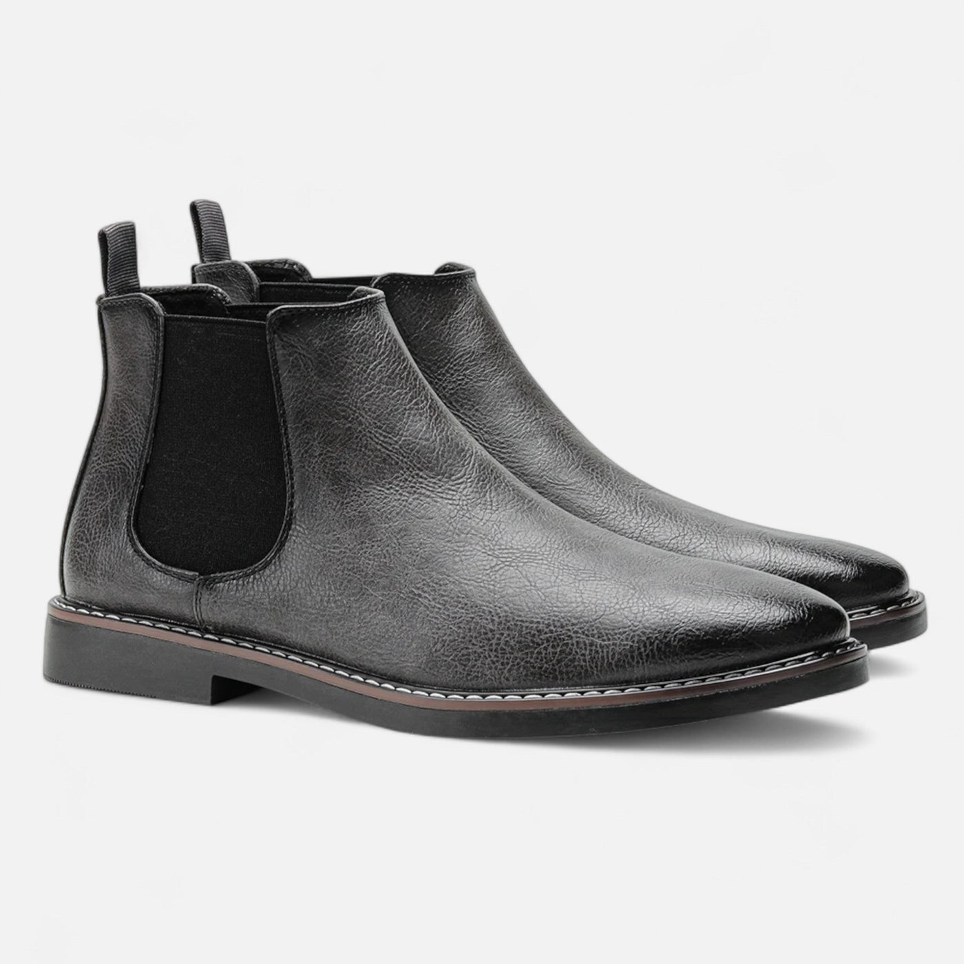 Black leather Chelsea boots with matching elastic side panels and grosgrain pull tabs, paired angled view featuring contrast white welt stitching and stacked heel detail