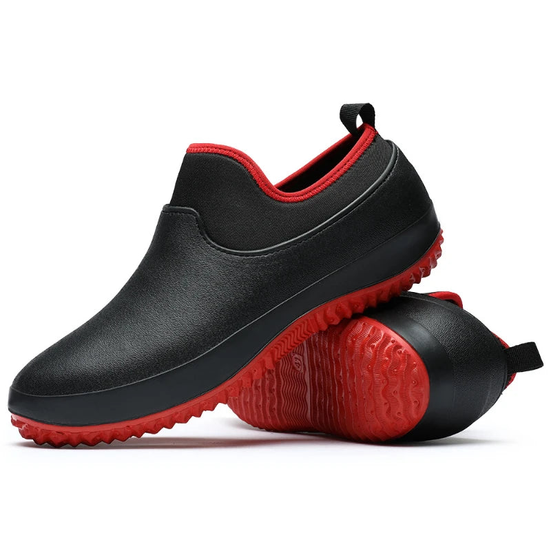Black slip-on garden shoes with red neoprene collar trim and matching red textured rubber outsole, paired stacked view showing deep tread pattern and rear pull loop