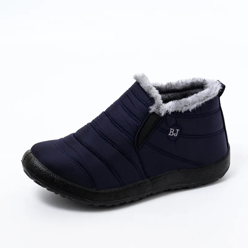 Navy blue insulated slip-on ankle boot with grey faux fur trim and elastic panel insert, side view displaying quilted water-resistant upper and treaded rubber outsole