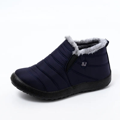 Navy blue insulated slip-on ankle boot with grey faux fur trim and elastic panel insert, side view displaying quilted water-resistant upper and treaded rubber outsole