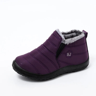 Purple quilted ankle bootie with grey faux fur collar and elasticated side panel, side perspective displaying horizontal quilting pattern and black rubber traction sole
