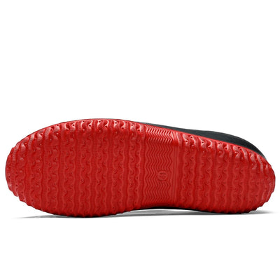 Red rubber outsole with multi-directional tread pattern, bottom view displaying wave design center channel and circular grip pods throughout sole surface