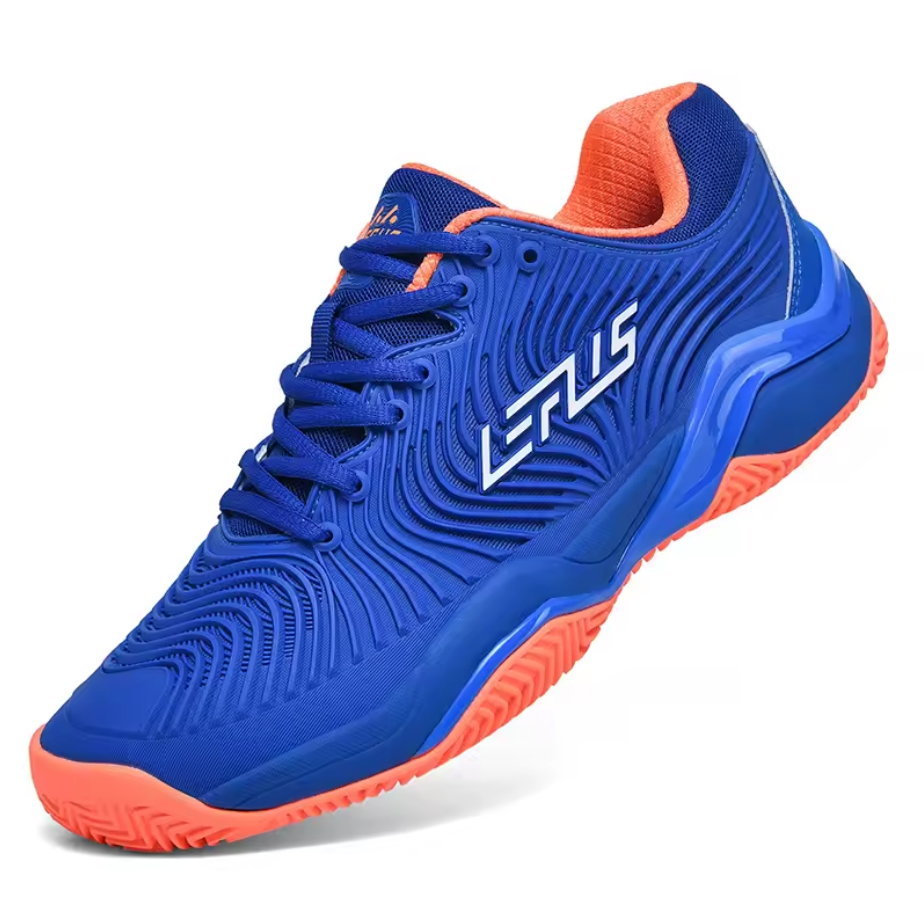 Royal blue indoor court trainer with coral orange collar lining and outsole accents, angled perspective displaying textured wave design upper and patterned grip base