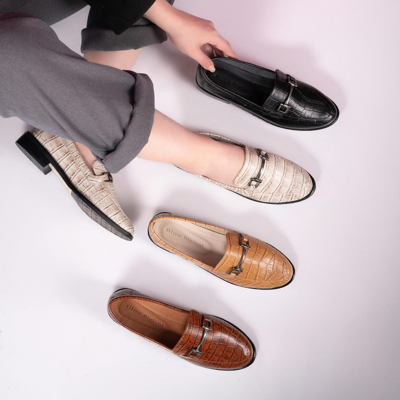 Women sitting on the set wearing loafers showing different colors of the model