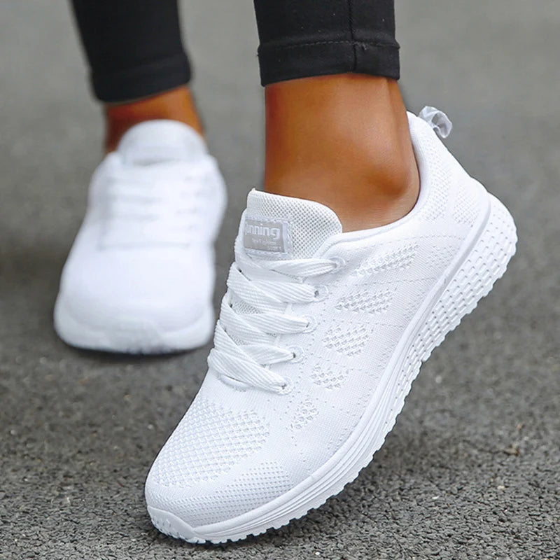White mesh athletic sneakers with tonal laces and padded collar, on-model close-up showing breathable knit upper construction and textured EVA midsole with tread pattern